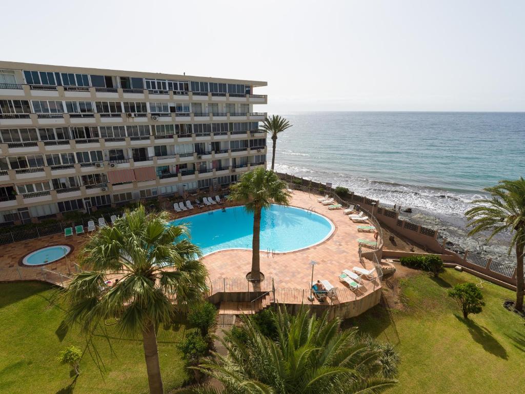 an aerial view of a hotel with a swimming pool and the ocean at RENOVADO APARTAMENTO 1º LINEA DE MAR in San Agustin