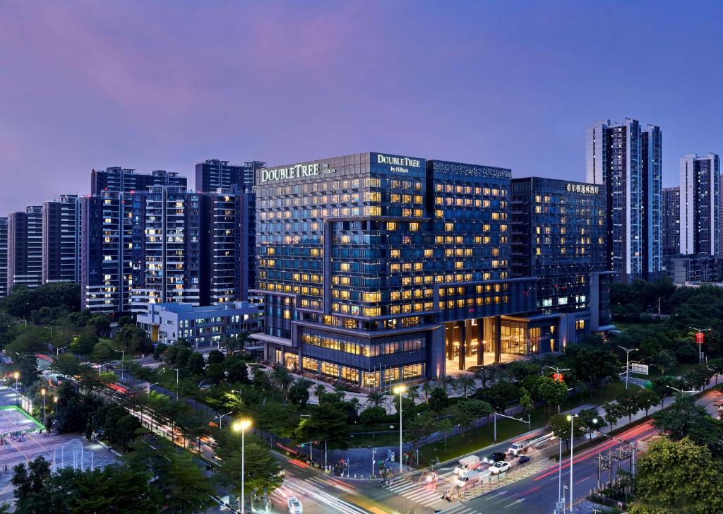 a large building with lights on in a city at Doubletree By Hilton Shenzhen Airport in Bao'an