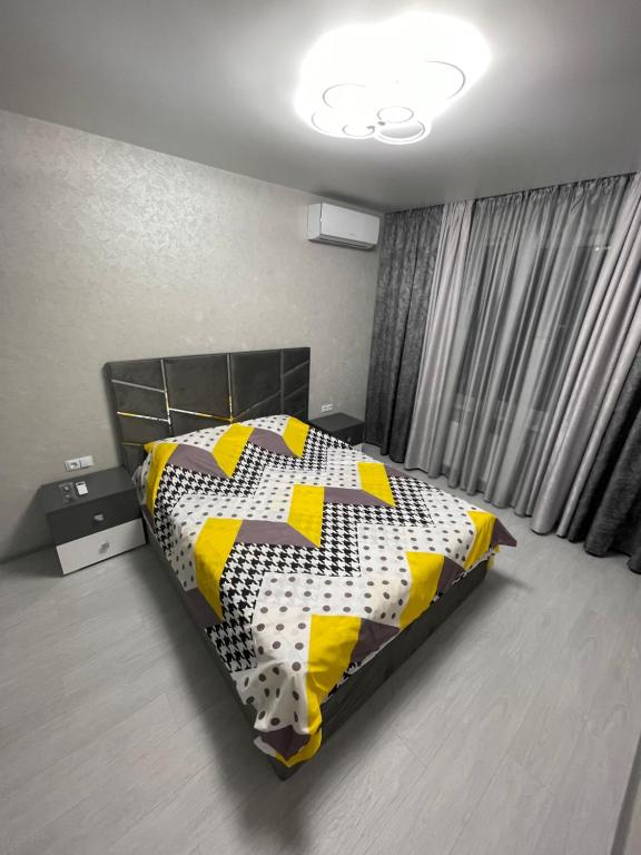 a bedroom with a bed with a black and yellow comforter at VIP new apartment Odessa in Odesa