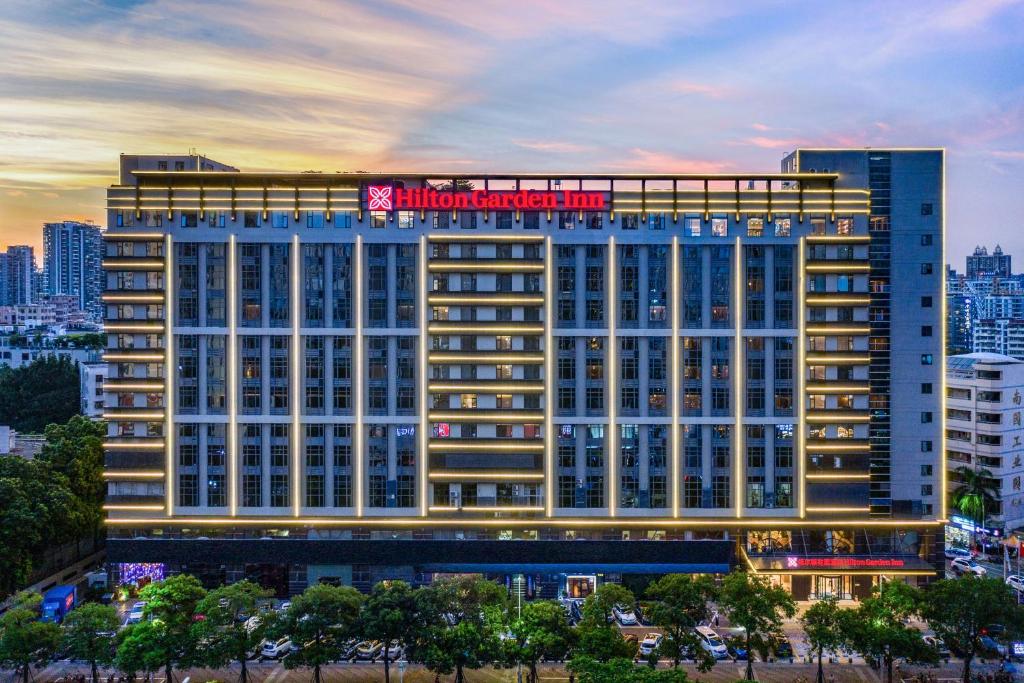 Un bâtiment avec un panneau en haut dans l'établissement Hilton Garden Inn Shenzhen Nanshan Avenue, à Shenzhen