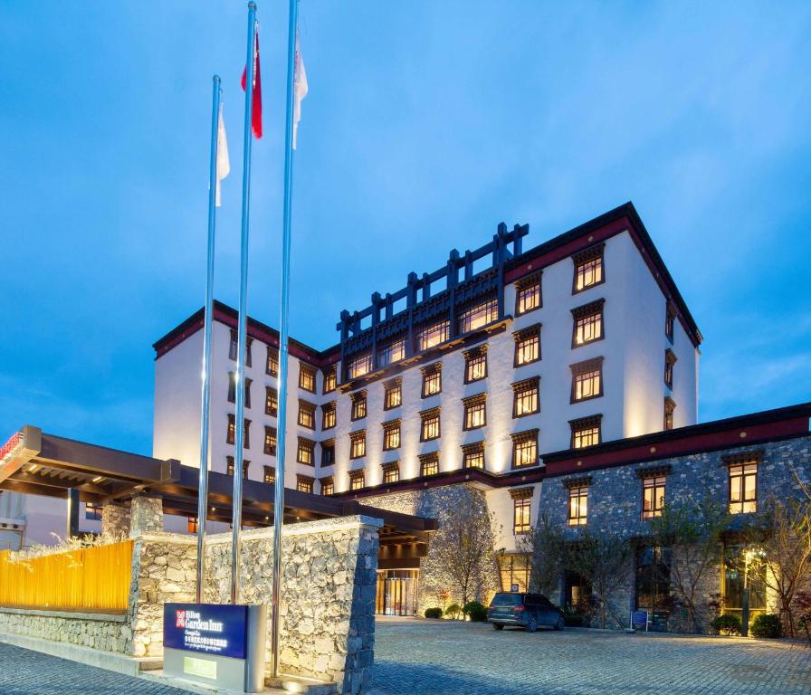 a hotel with flags in front of a building at Hilton Garden Inn Shangri-La in Shangri-La