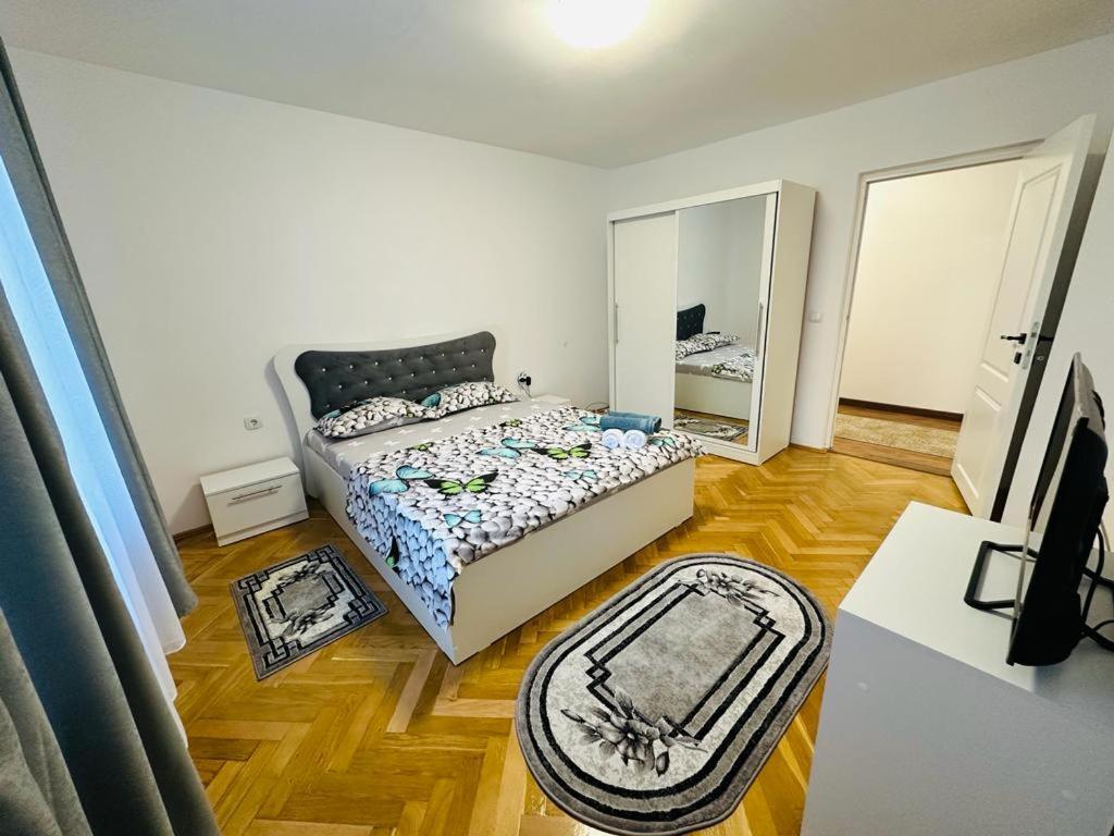 Dormitorio pequeño con cama y espejo en Casa Blidariu, en Băile Herculane