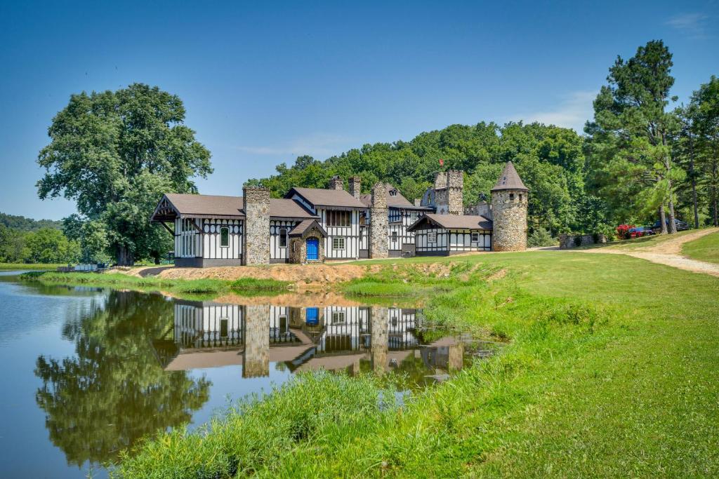 uma casa grande com um reflexo na água em Missouri Castle with Private Lake, Pool and 100 Acres! em Avon