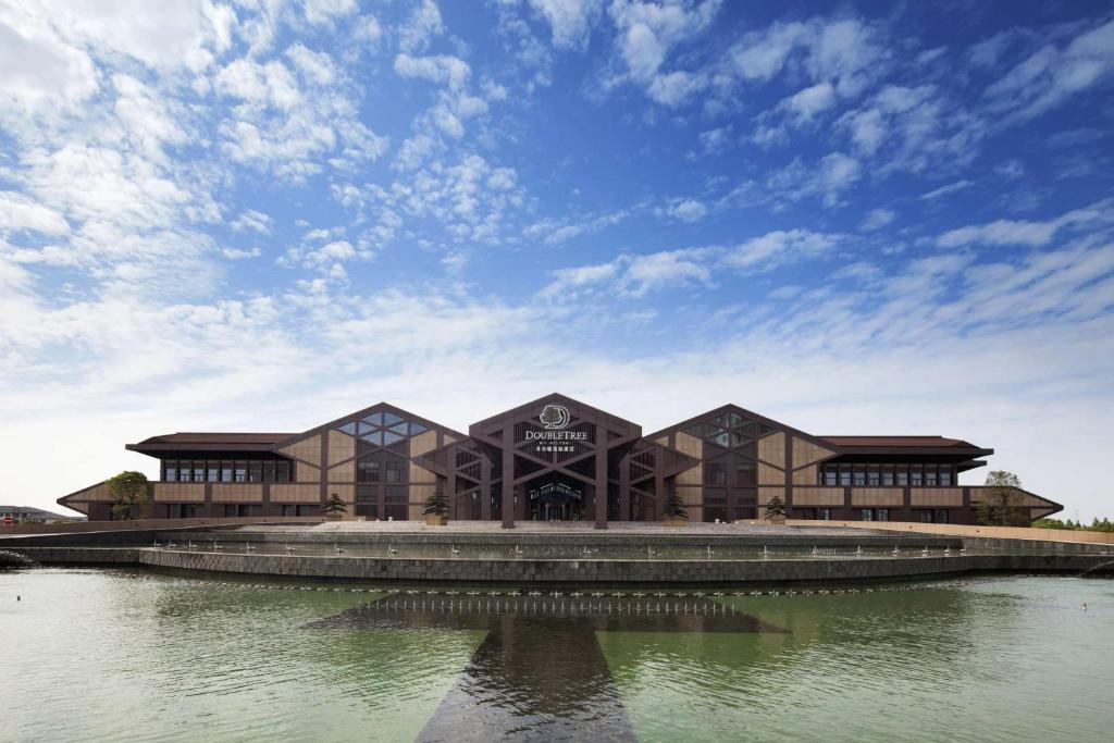 a large building in the middle of a body of water at DoubleTree By Hilton Jiaxing in Jiaxing