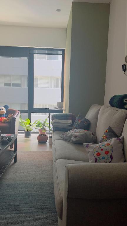 a living room with a couch and a large window at Apartamento Nuevo Polanco in Mexico City