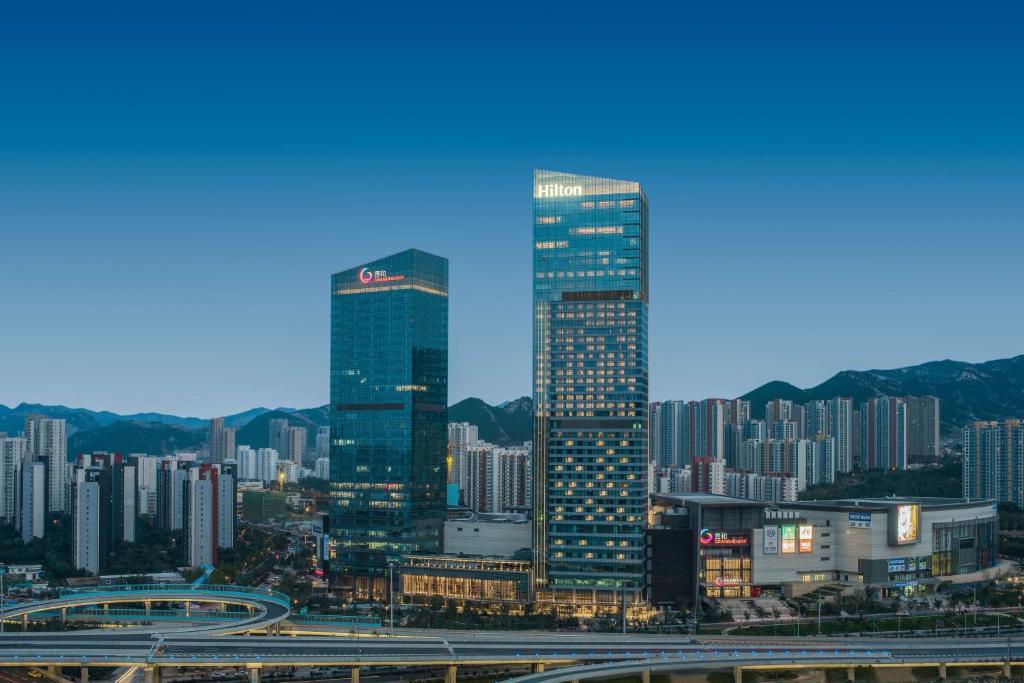 eine Skyline der Stadt mit hohen Wolkenkratzern und einer Autobahn in der Unterkunft Hilton Jinan South Hotel & Residences in Jinan