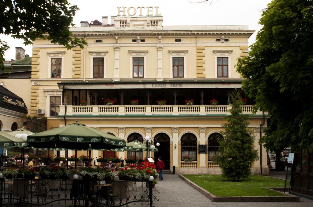 a hotel with a table in front of a building at Wien Hotel in Lviv