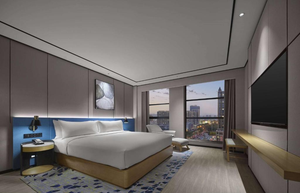 une chambre d'hôtel avec un lit et une télévision dans l'établissement Hilton Garden Inn Xingtai Xiangdu District, à Ta-liang-chuang