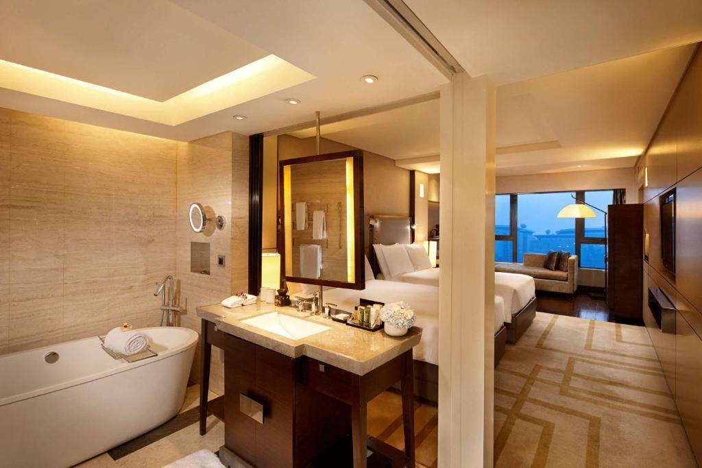 y baño con cama, bañera y lavamanos. en Hilton Beijing Wangfujing, en Beijing