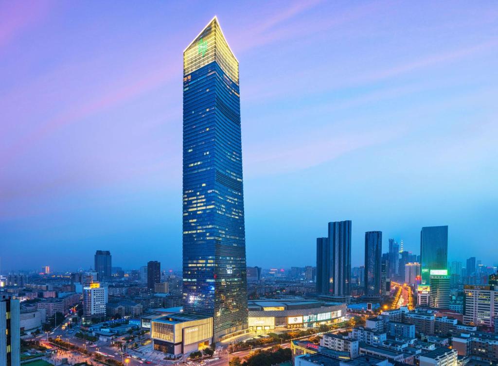 a tall skyscraper in a city at night at Conrad Shenyang in Shenyang