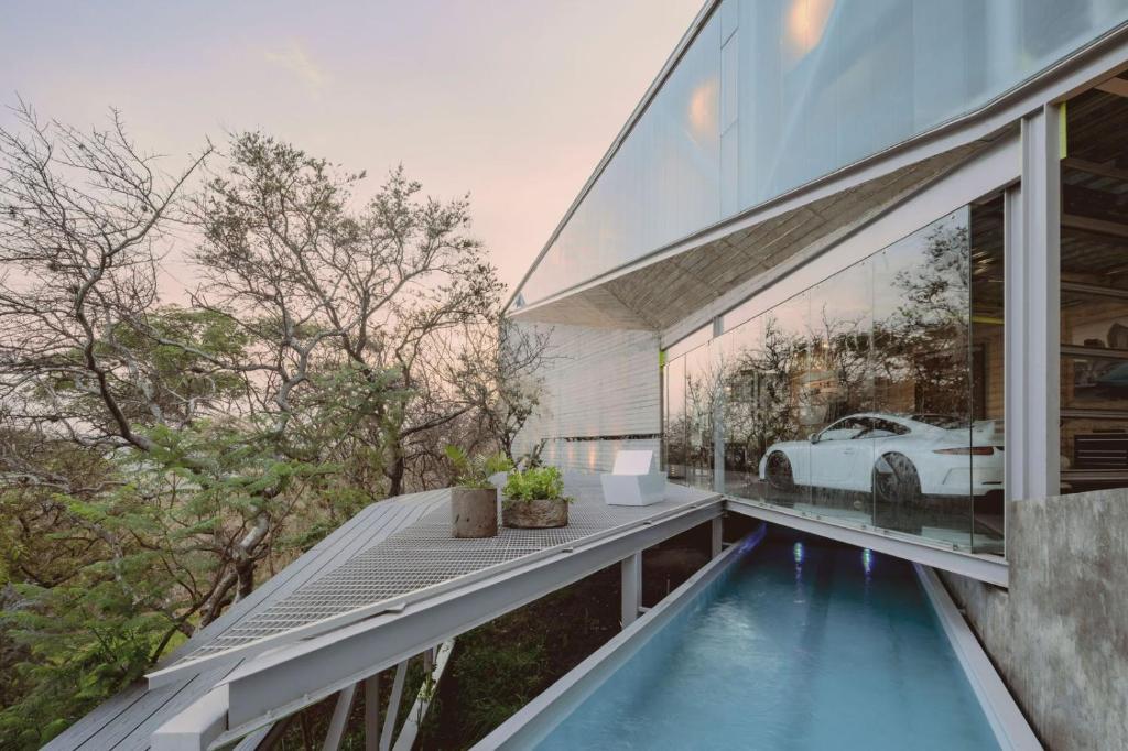 a house with a swimming pool and a car in the window at Luxury Villa Cañadas in Guadalajara