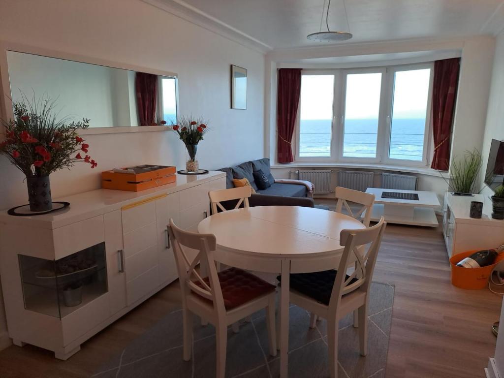 a kitchen and living room with a table and chairs at Appartement met prachtig zicht op zee in Ostend