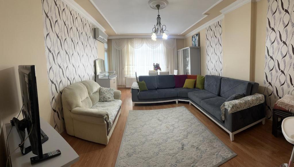 a living room with a blue couch and a chair at Doğal apart in Trabzon