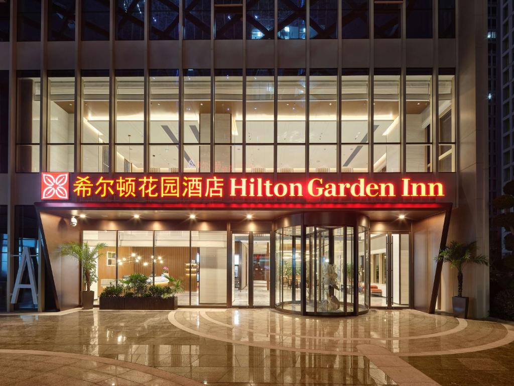 un edificio con un millón de letreros de posada en el jardín delante de él en Hilton Garden Inn Hangzhou Xixi Zijingang en Hangzhou