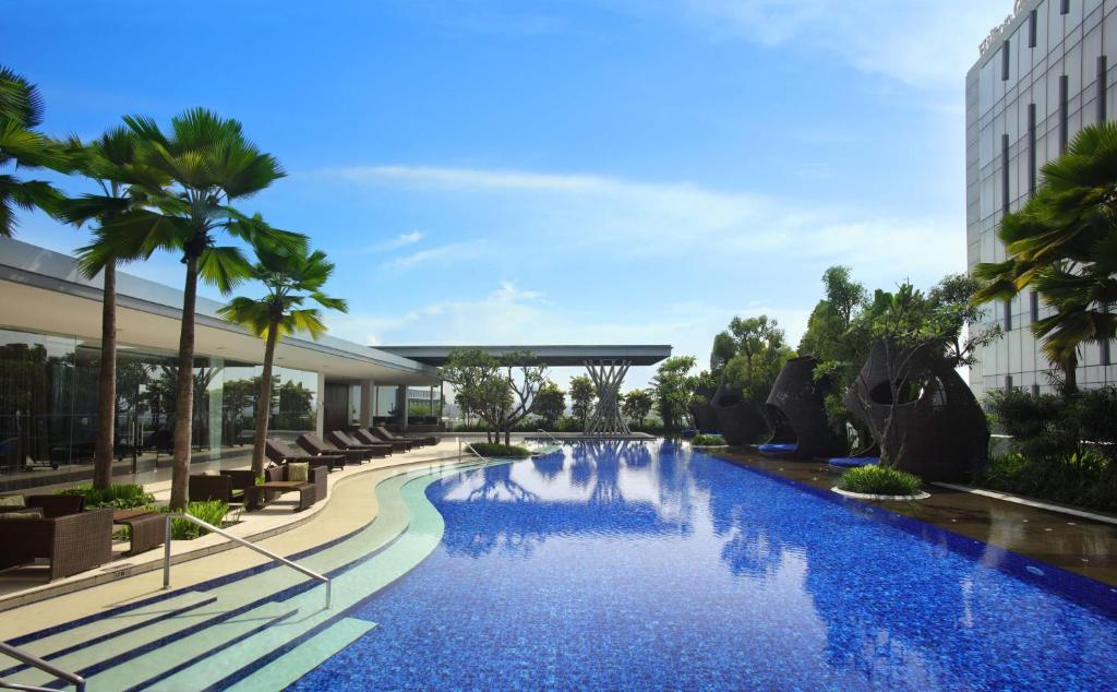 هيلتون باندونغ في باندونغ: وجود مسبح في الفندق مع الكراسي والنخيل