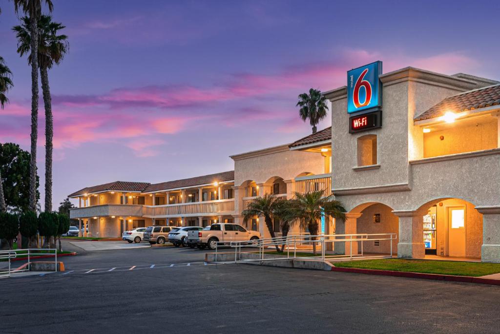 um hotel com carros estacionados num parque de estacionamento em Motel 6-Carlsbad, CA Beach em Carlsbad