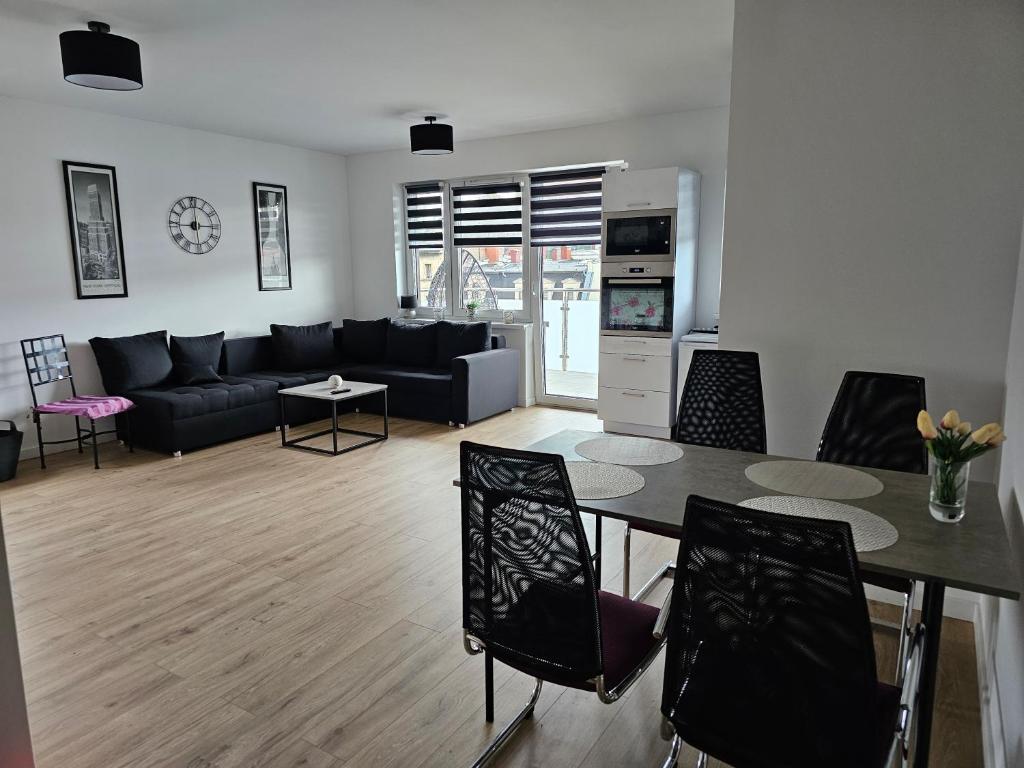Apartament Flover في يلينيا غورا: غرفة معيشة مع أريكة وطاولة وكراسي