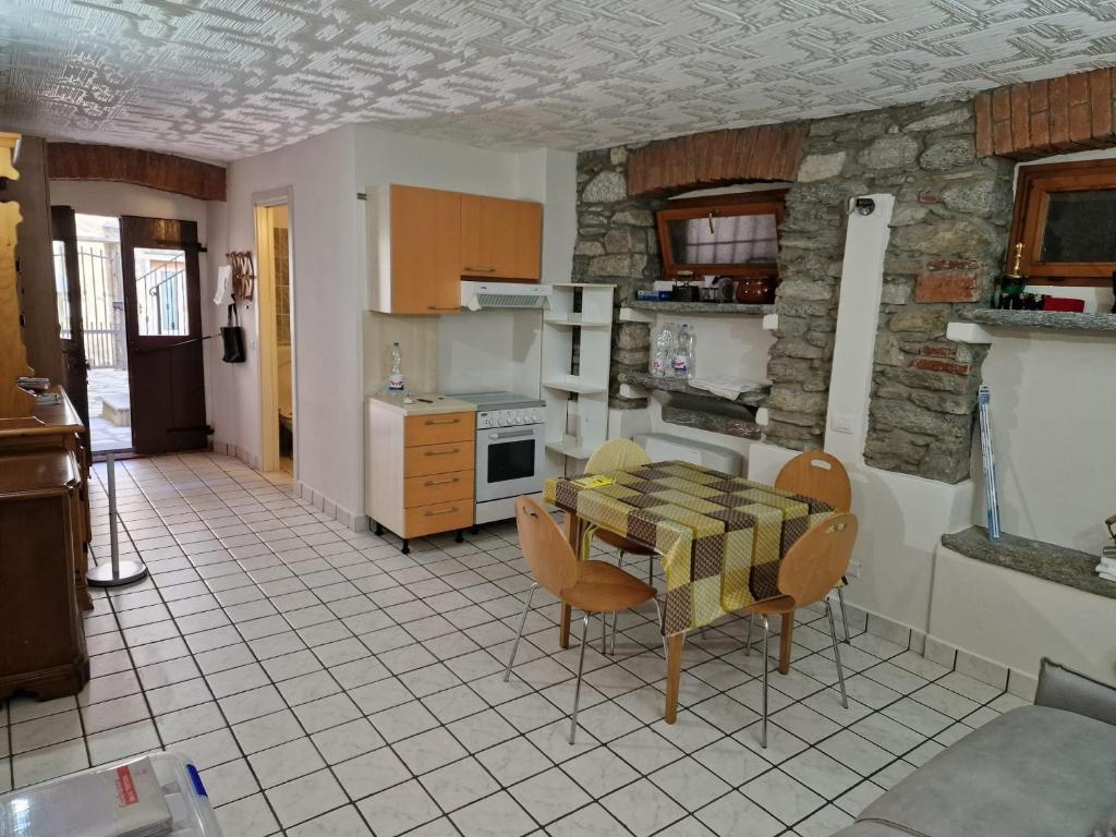 - une cuisine avec une table et des chaises dans la chambre dans l'établissement DIANA HOUSE, à Colazza
