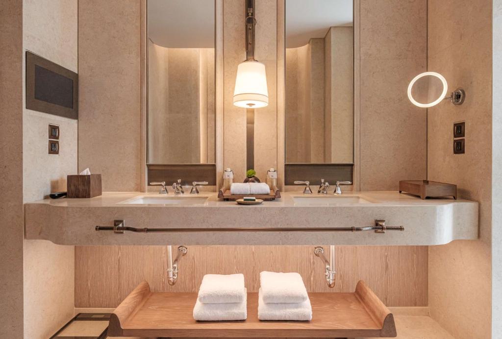 A refined double-vanity bathroom with mirrored storage and neatly presented towels.