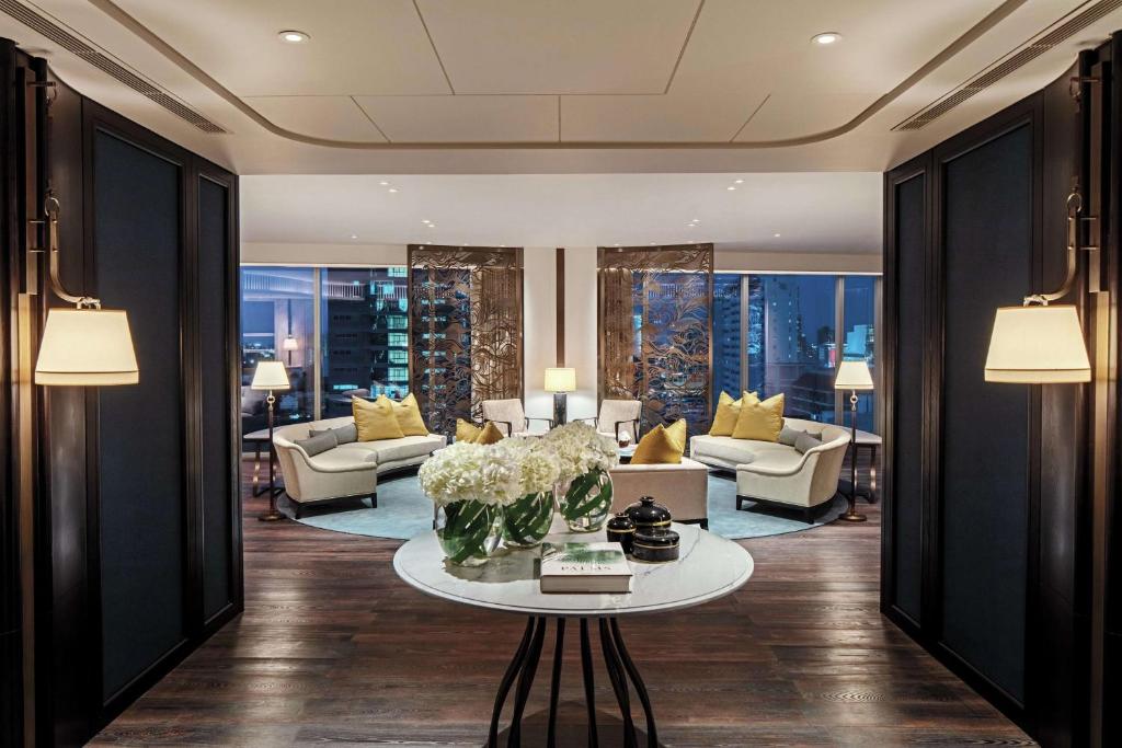 A formal sitting room arranged around a flower-topped console.