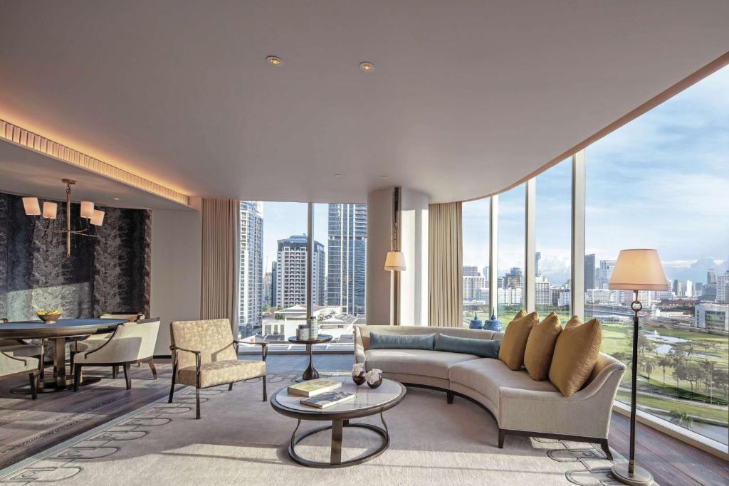 A curved-window suite lounge with a separate dining area.