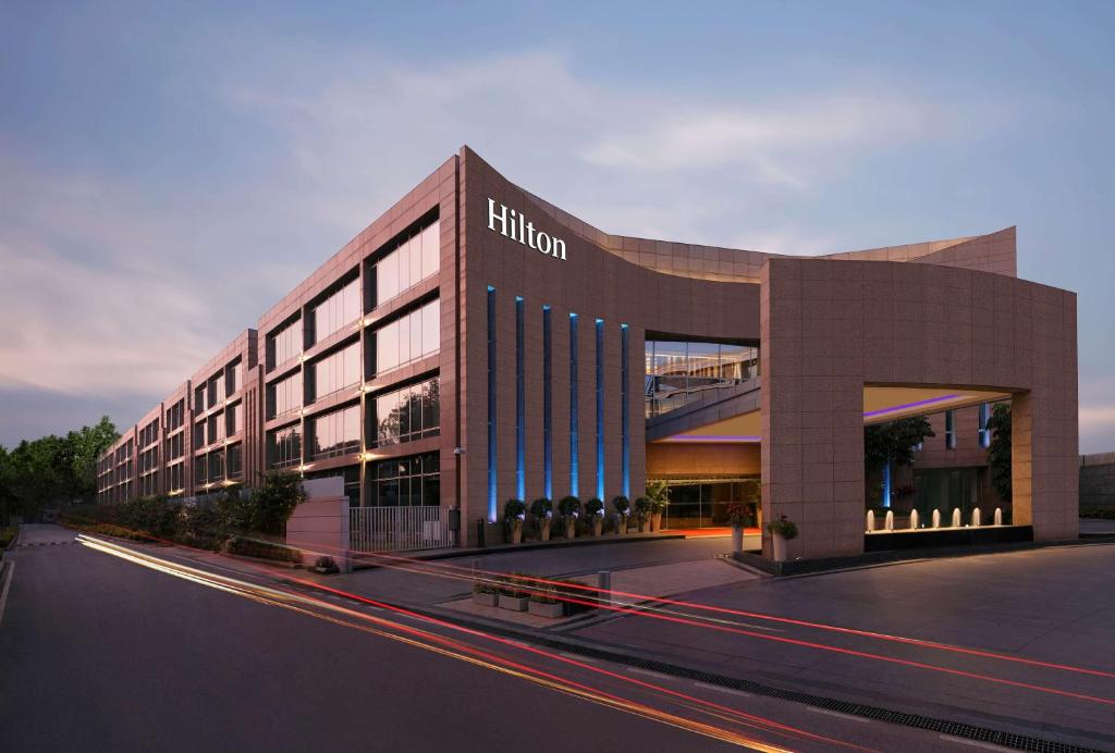 un bâtiment avec un panneau sur son côté dans l'établissement Hilton Bangalore Embassy GolfLinks, à Bangalore