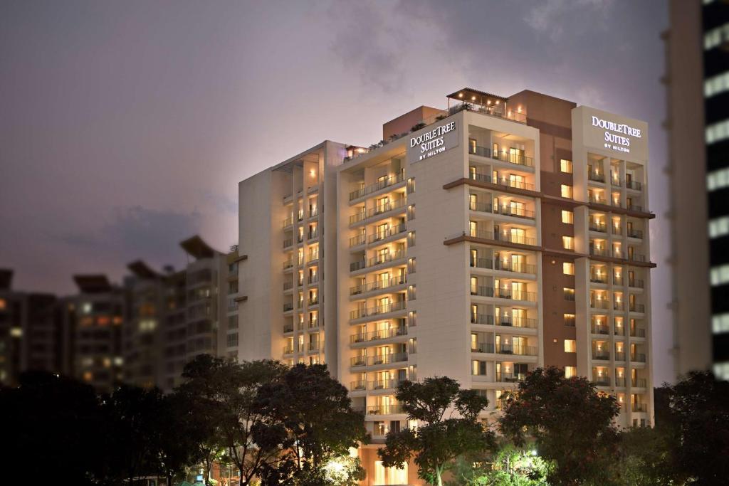 un grand bâtiment éclairé dans une ville dans l'établissement DoubleTree Suites by Hilton Bengaluru Outer Ring Road, à Bangalore