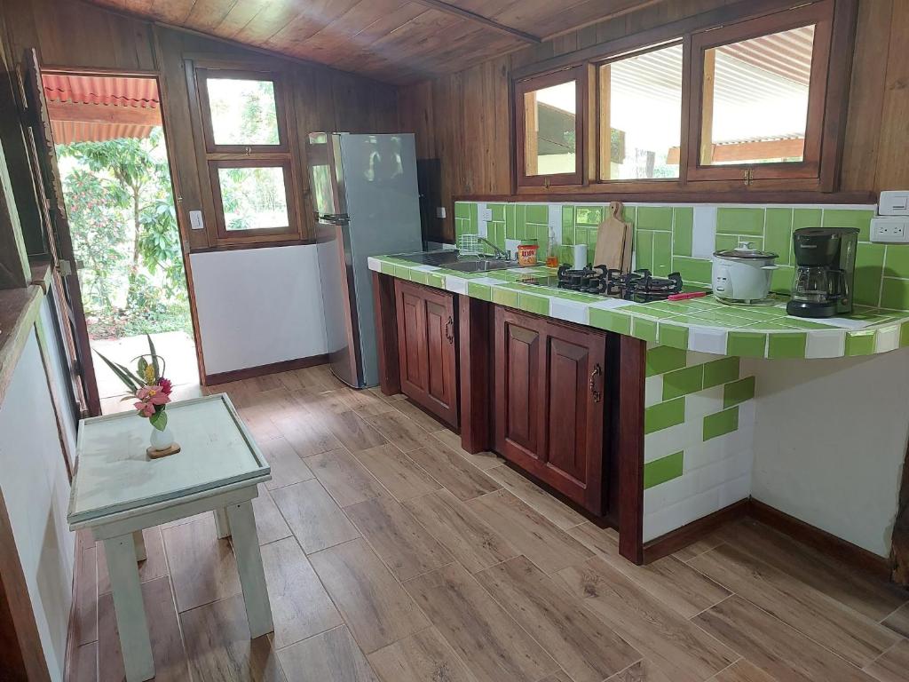 una cocina con azulejos verdes y blancos en las encimeras en Casa Mairena en Caño Negro