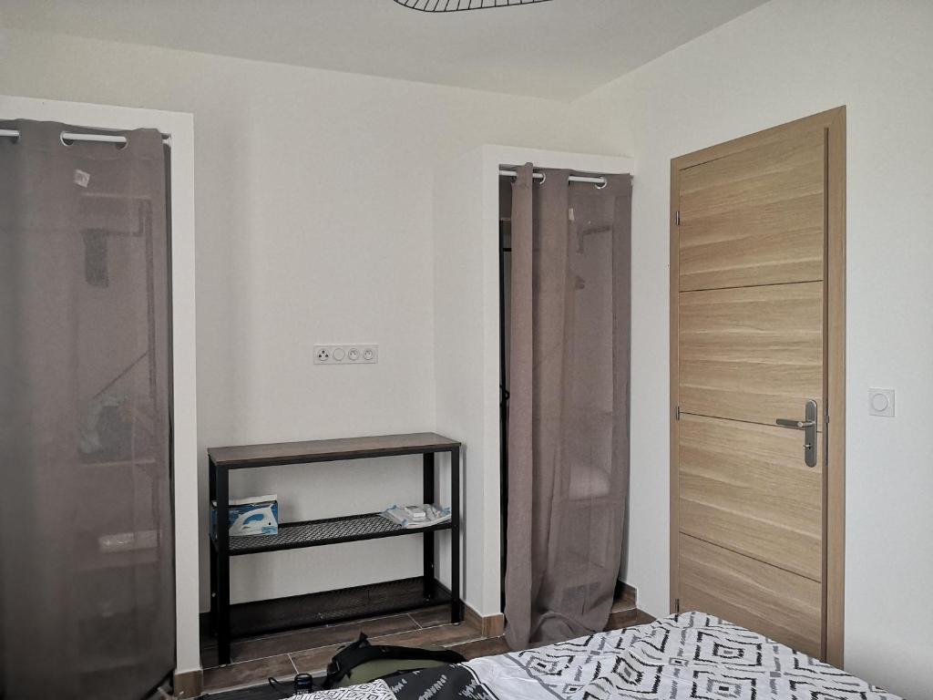 um quarto com uma cama e uma porta de madeira em Bas de Maison em Biguglia