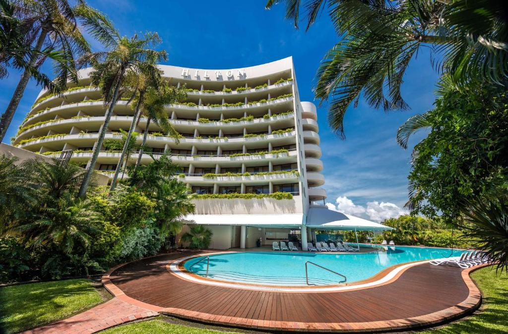 een hotel met een zwembad voor een gebouw bij Hilton Cairns in Cairns