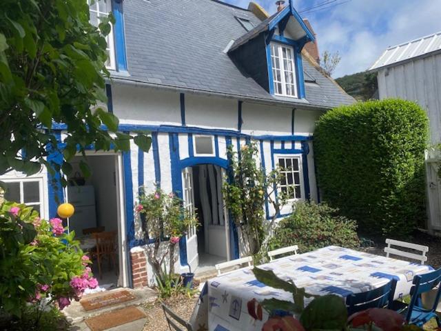 uma casa azul e branca com uma mesa em frente em La Petite Fanny em Étretat