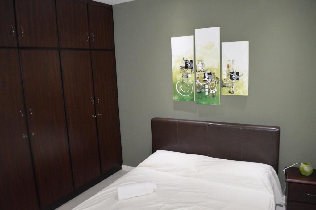 Apartment No 18 - West Terraces في فليك-إن-فلاك: غرفة نوم بها سرير و لوحتين على الحائط