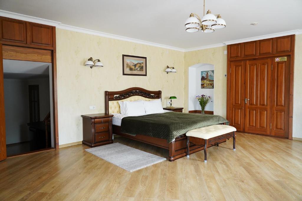 1 dormitorio con 1 cama y suelo de madera en Spadok, en Kamianets-Podilskyi