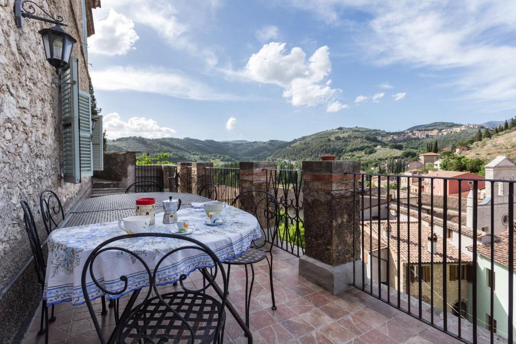 un patio con tavolo e sedie sul balcone. di La Loggia Sul Nera ad Arrone