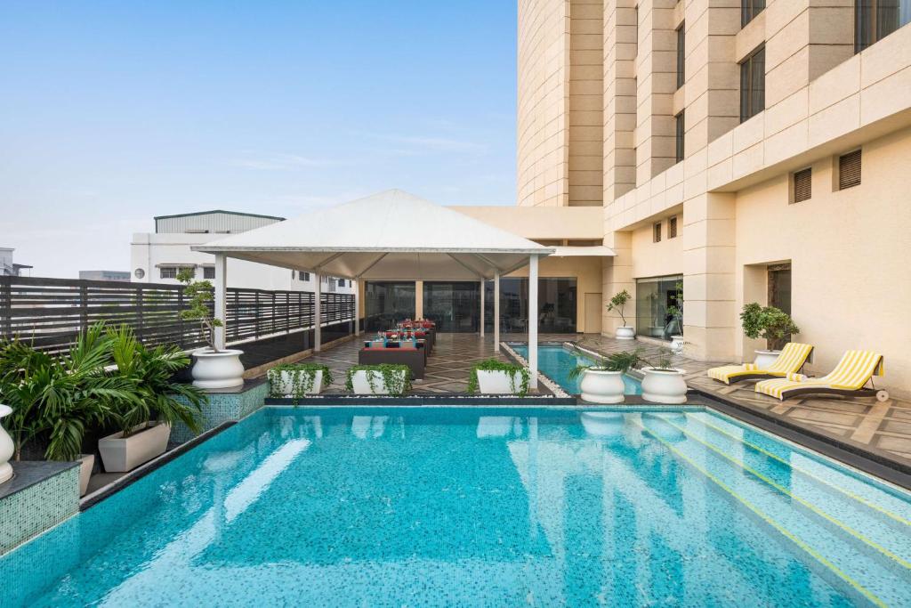 einen Pool auf der Dachterrasse eines Hotels in der Unterkunft Hilton Jaipur in Jaipur