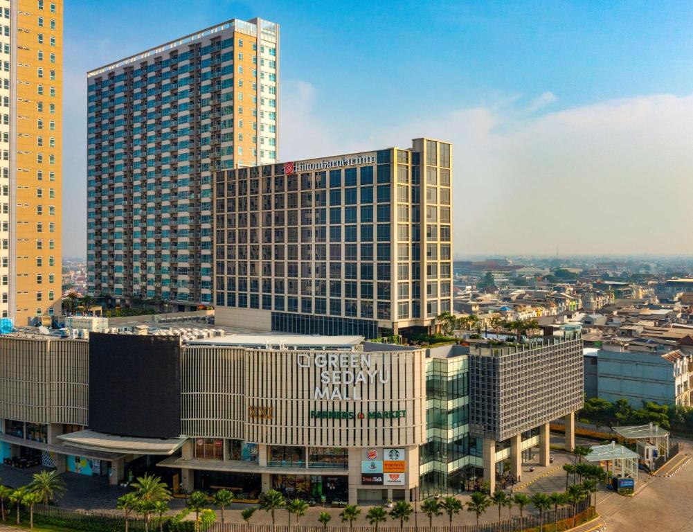 vista su un alto edificio in città di Hilton Garden Inn Jakarta Taman Palem a Giacarta