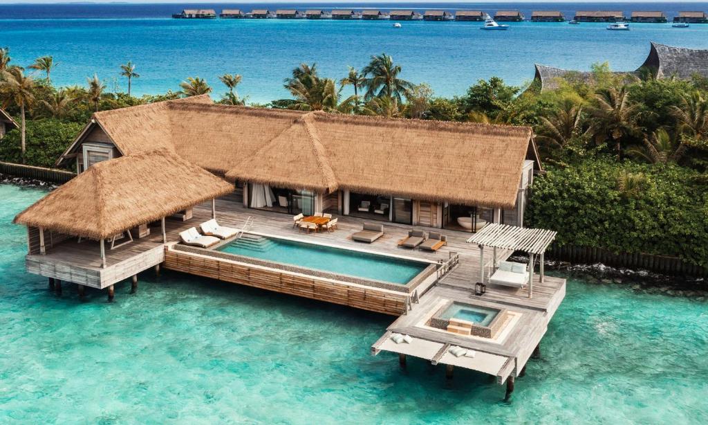 a house in the water with a swimming pool at Waldorf Astoria Maldives Ithaafushi in South Male Atoll