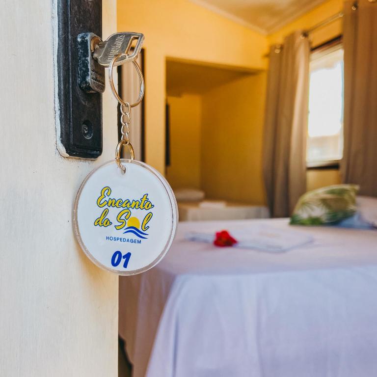a key chain attached to a room with a bed at Encanto do Sol Hospedagem in Icaraí