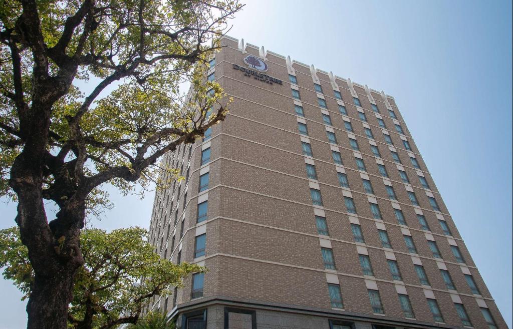 wysoki budynek z zegarem na boku w obiekcie DoubleTree by Hilton Hotel Naha w mieście Naha