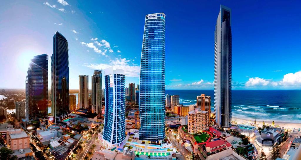 eine Skyline der Stadt mit hohen Gebäuden und dem Meer in der Unterkunft Hilton Surfers Paradise Hotel & Residences in Gold Coast