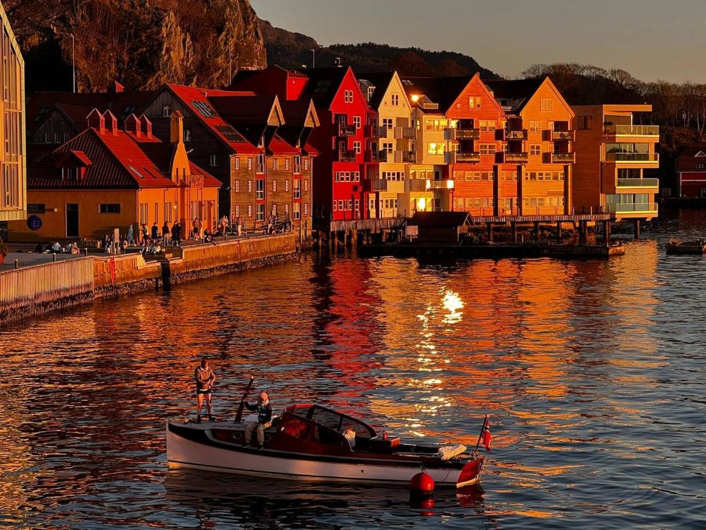 een boot in het water voor een stad bij Central Seafront Apartments with Parking and Self Check-In! in Bergen