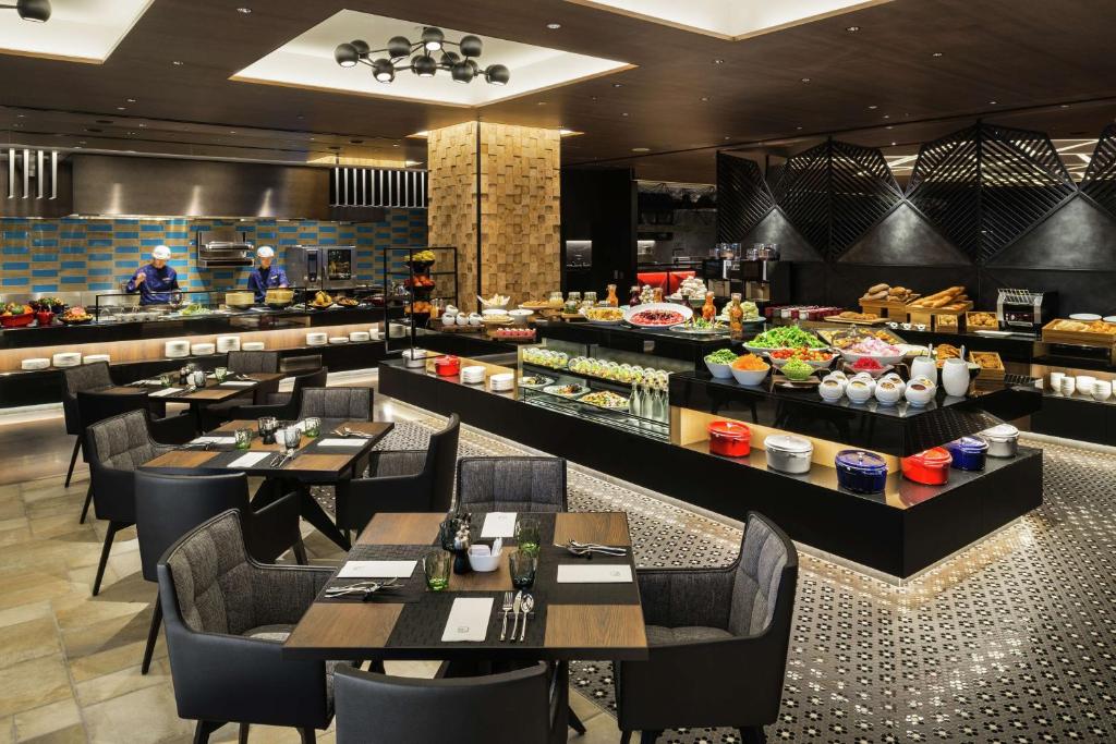 a restaurant with tables and chairs and a buffet at Hilton Osaka Hotel in Osaka
