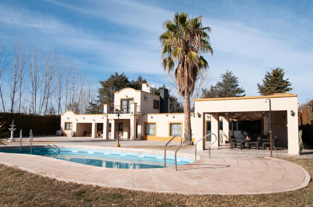 a house with a swimming pool and a palm tree at La Moni in Las Compuertas