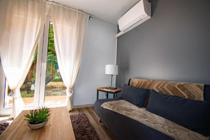 un salon avec un canapé et une grande fenêtre dans l'établissement Les quatres loges, à Aix-en-Provence