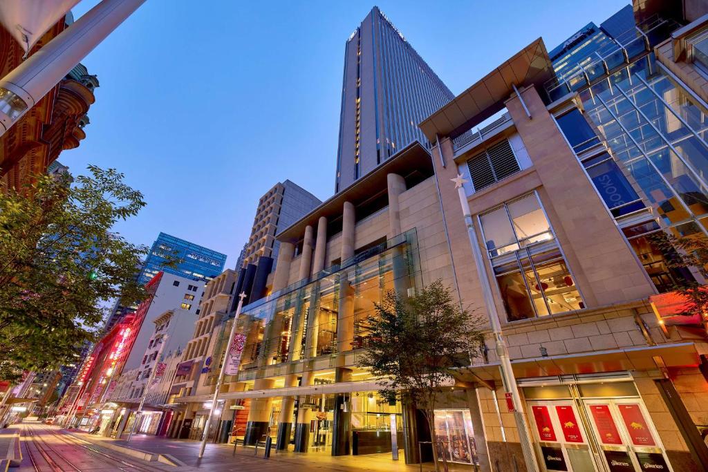 uma rua da cidade à noite com edifícios altos em Hilton Sydney em Sydney