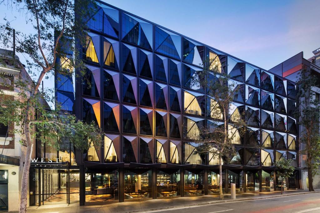 シドニーにあるウェスト ホテル シドニー キュリオ コレクション バイ ヒルトンの窓が多い建物の外観