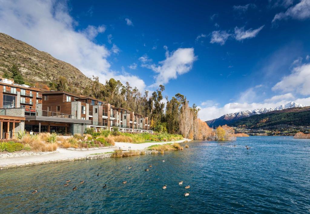 Blick auf einen Fluss mit Gebäuden am Ufer in der Unterkunft Hilton Queenstown Resort & Spa in Queenstown