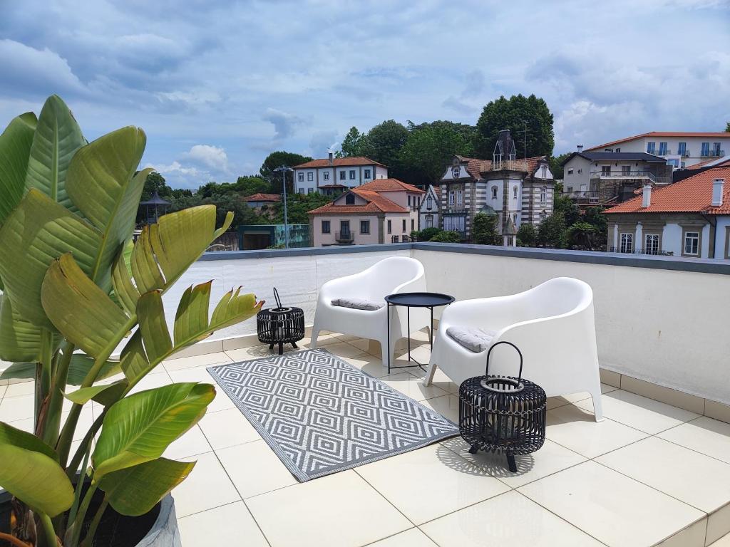 蓬蒂迪利馬的住宿－Da' Vila - Alojamento Local，一个带两把椅子和一张桌子的庭院