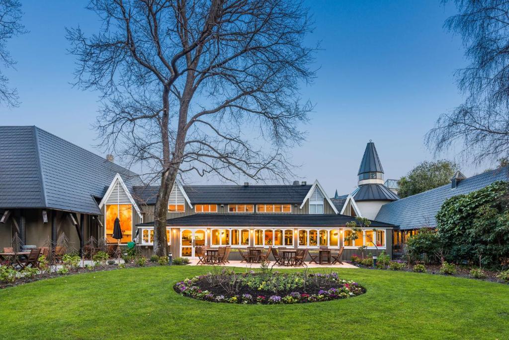 an exterior view of a house with a yard at Chateau On The Park - Christchurch, A Doubletree By Hilton in Christchurch