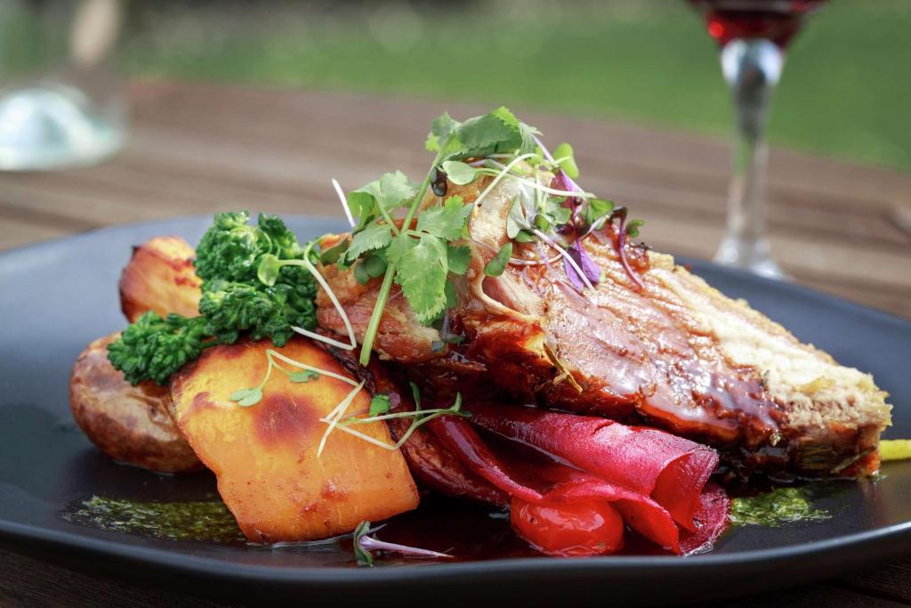 a plate of food with meat and vegetables on a table at Chateau On The Park - Christchurch, A Doubletree By Hilton in Christchurch